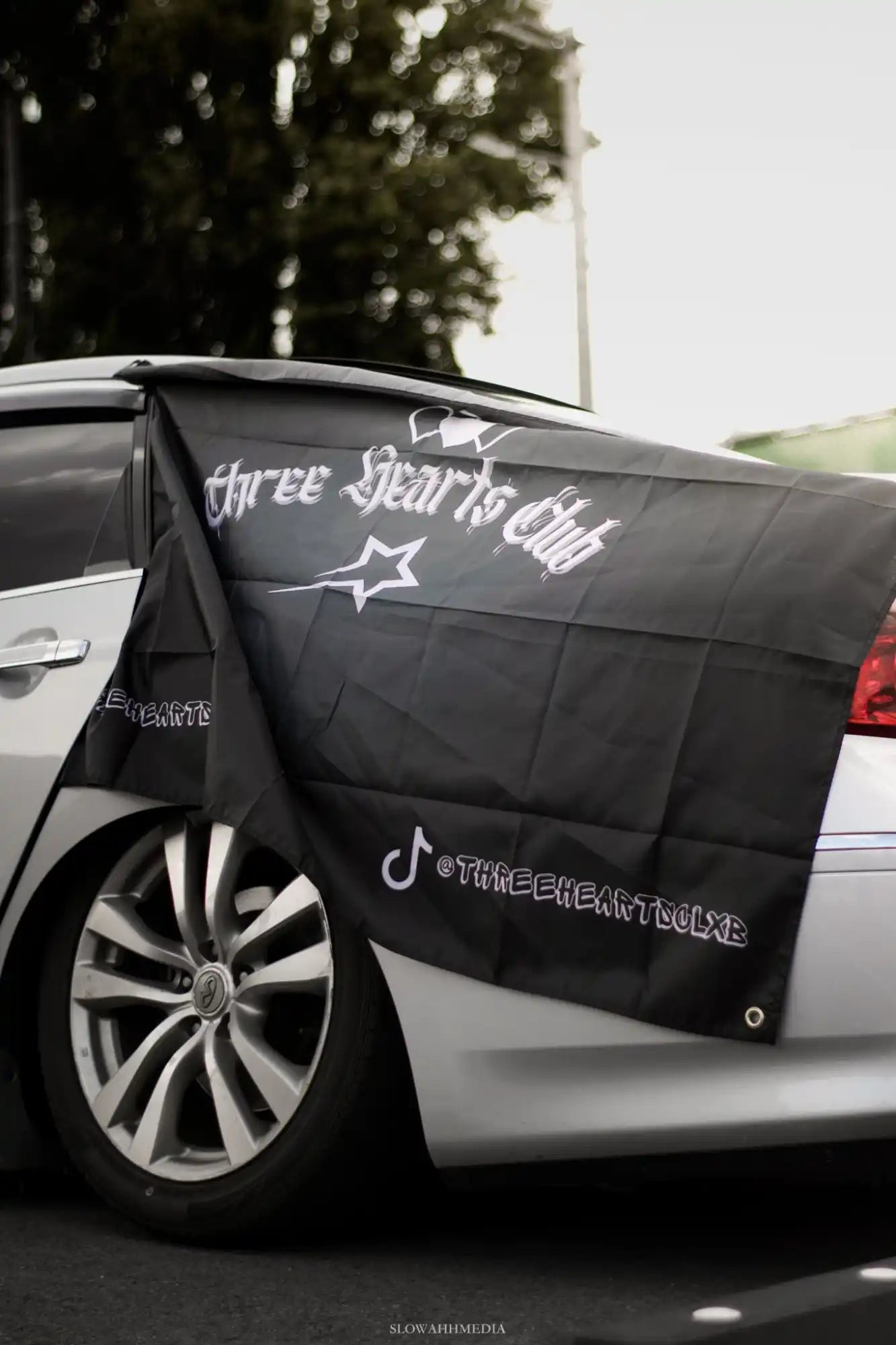 Black flag with ’Three Hearts Club’ text.
